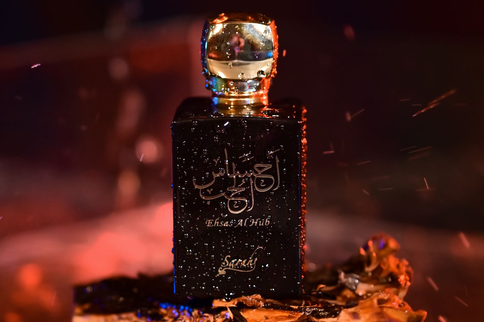 A dark, moody attar perfume bottle photographed with embers and warm light
