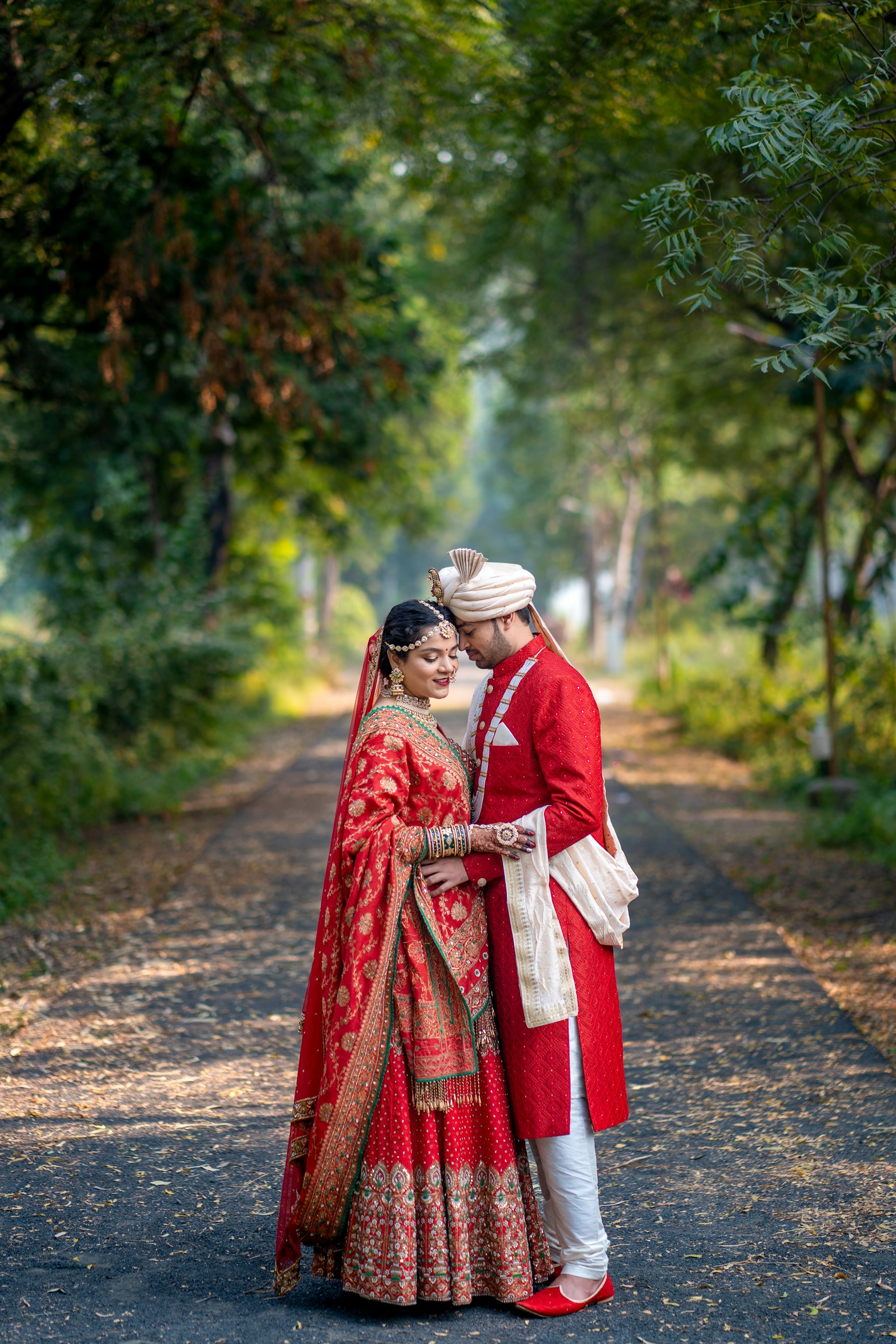An Indian couple photographed on a tree-lined path