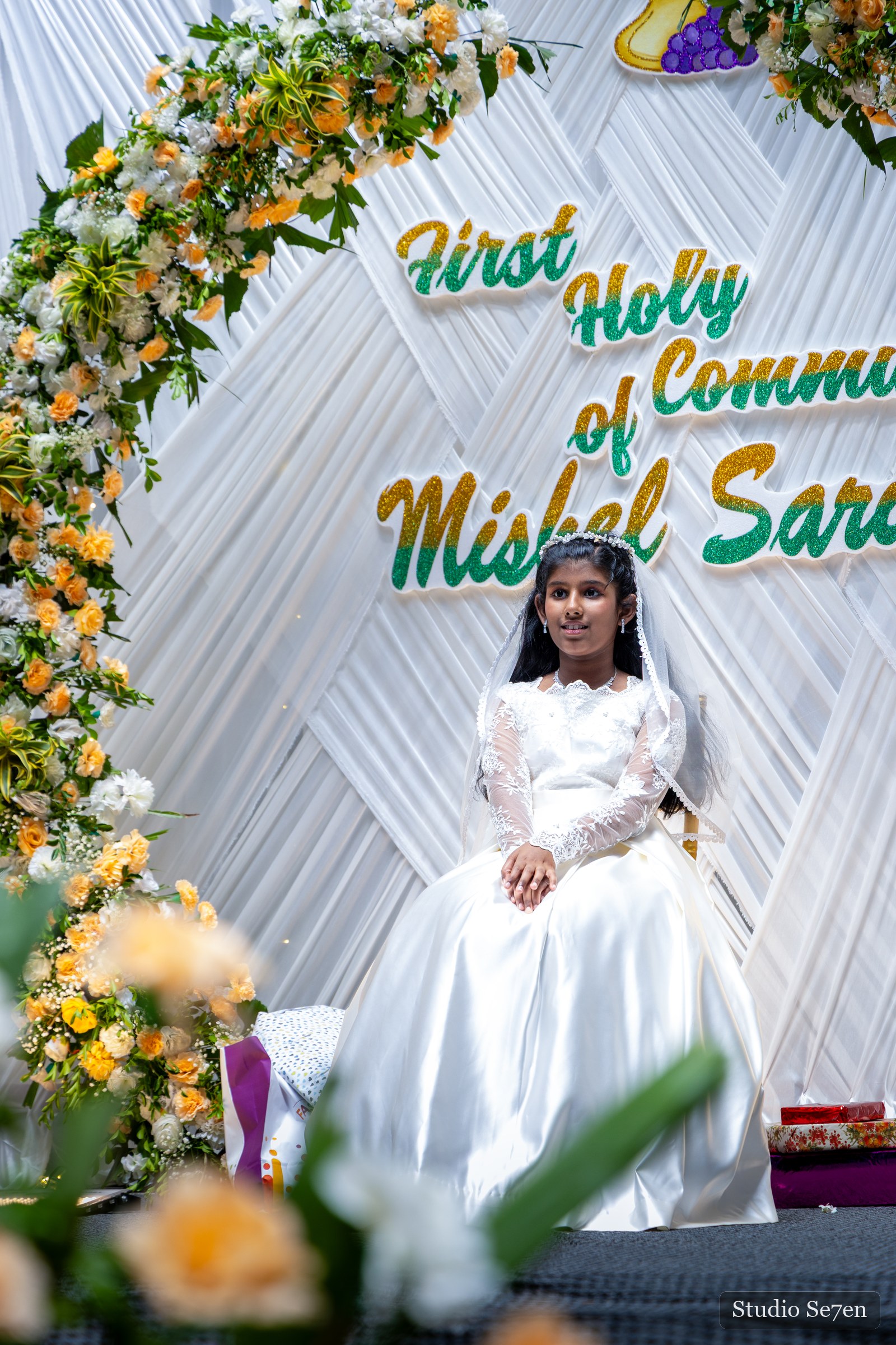 A First Holy Communion portrait in white ceremonial dress