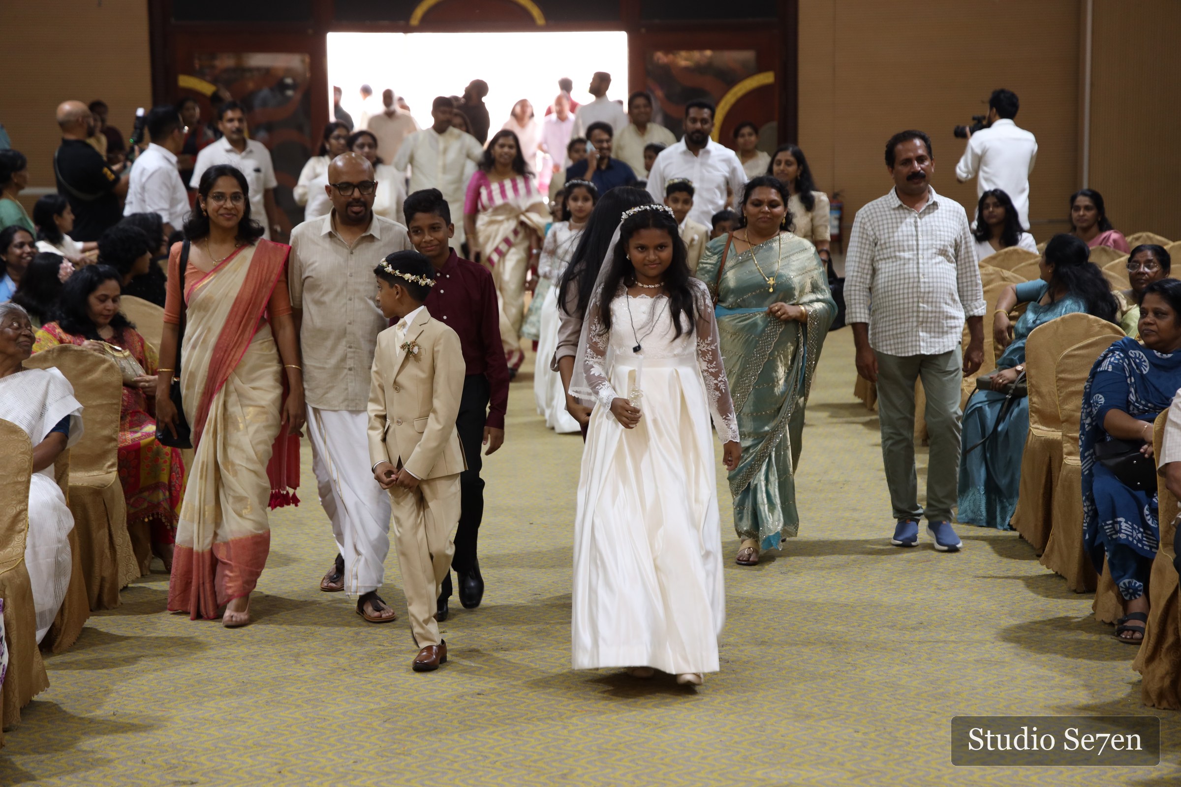 First Holy Communion children entering the hall with their families