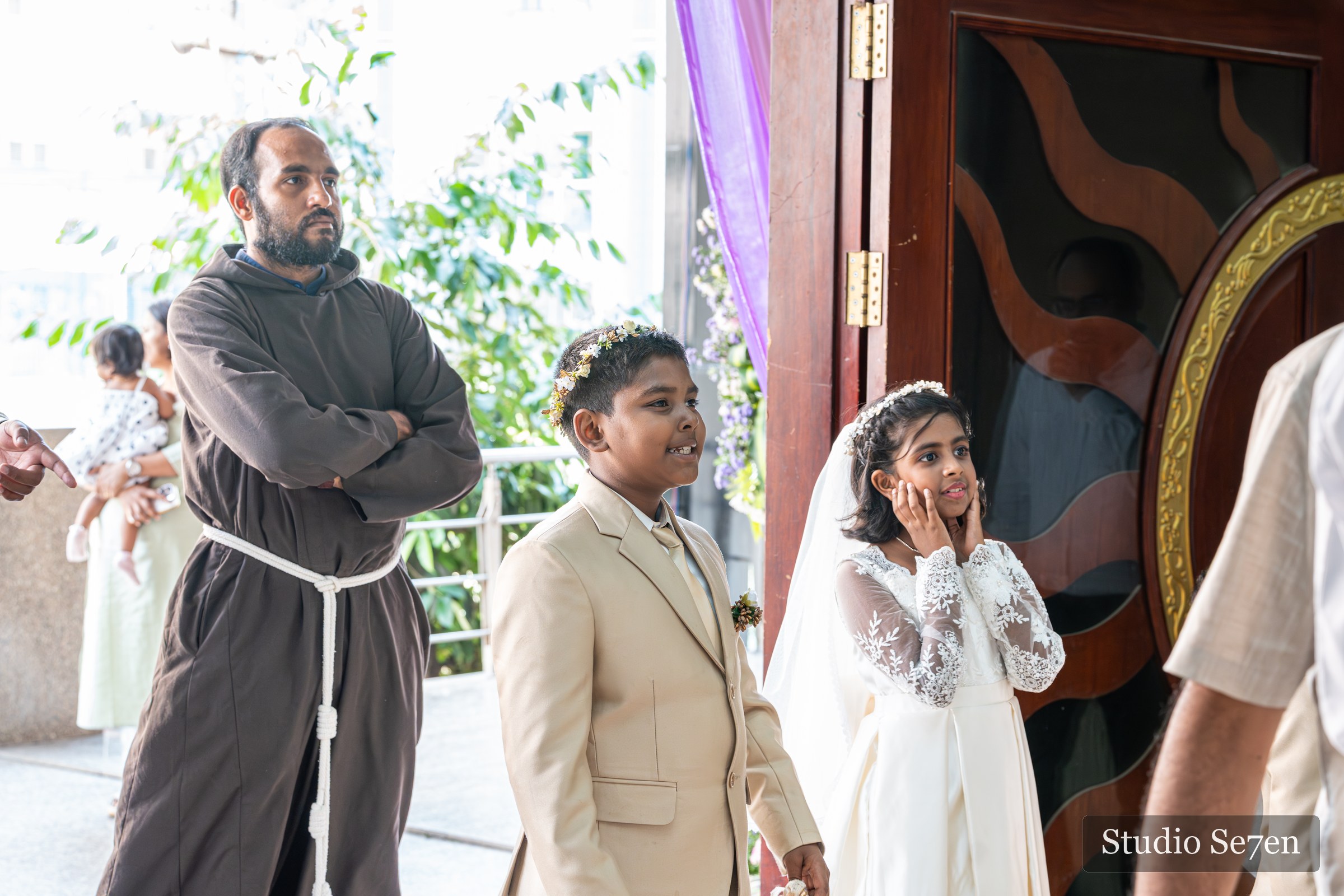 A priest accompanying two First Holy Communion children at the entrance