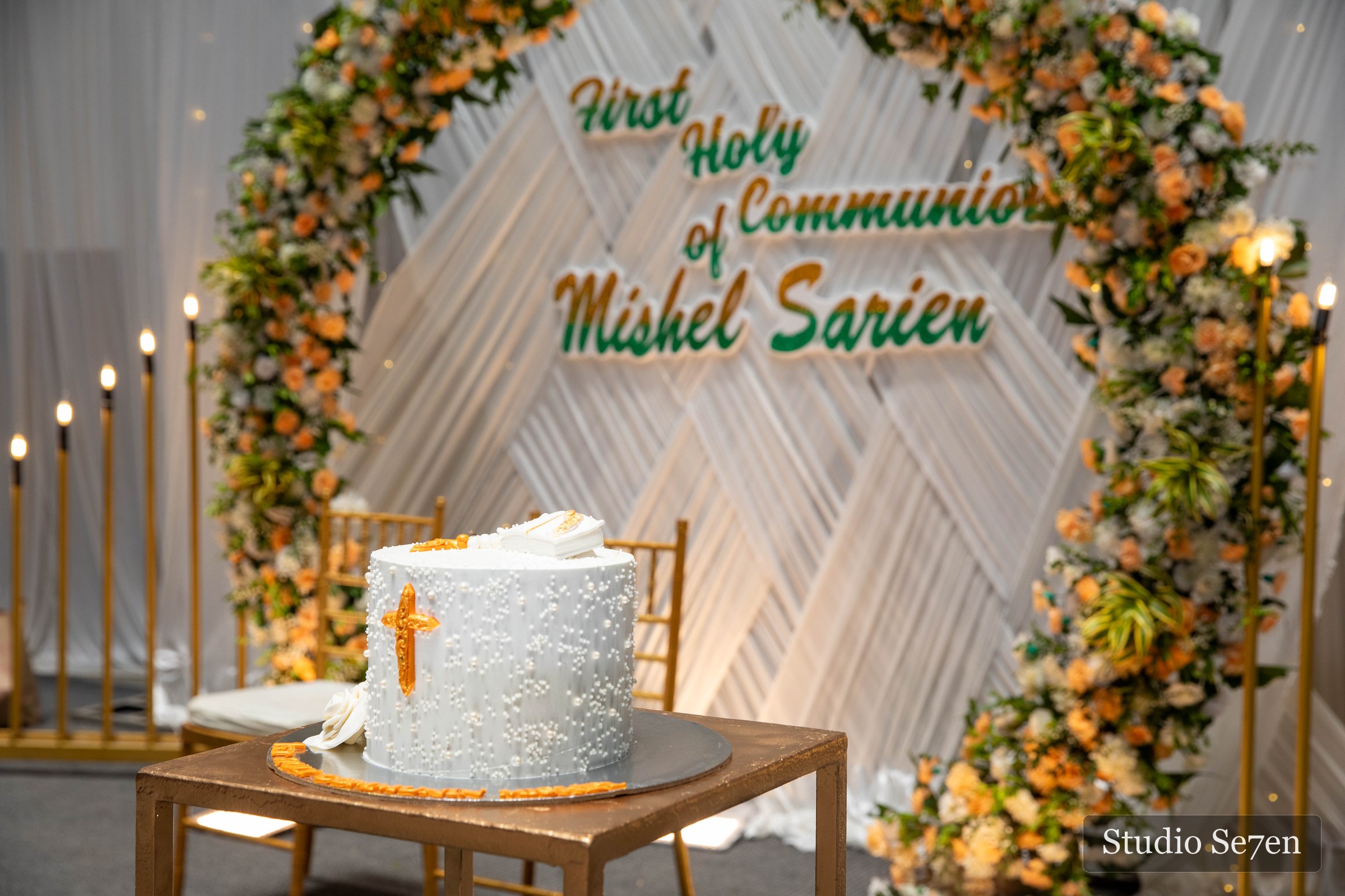 First Holy Communion cake framed by flowers and candles