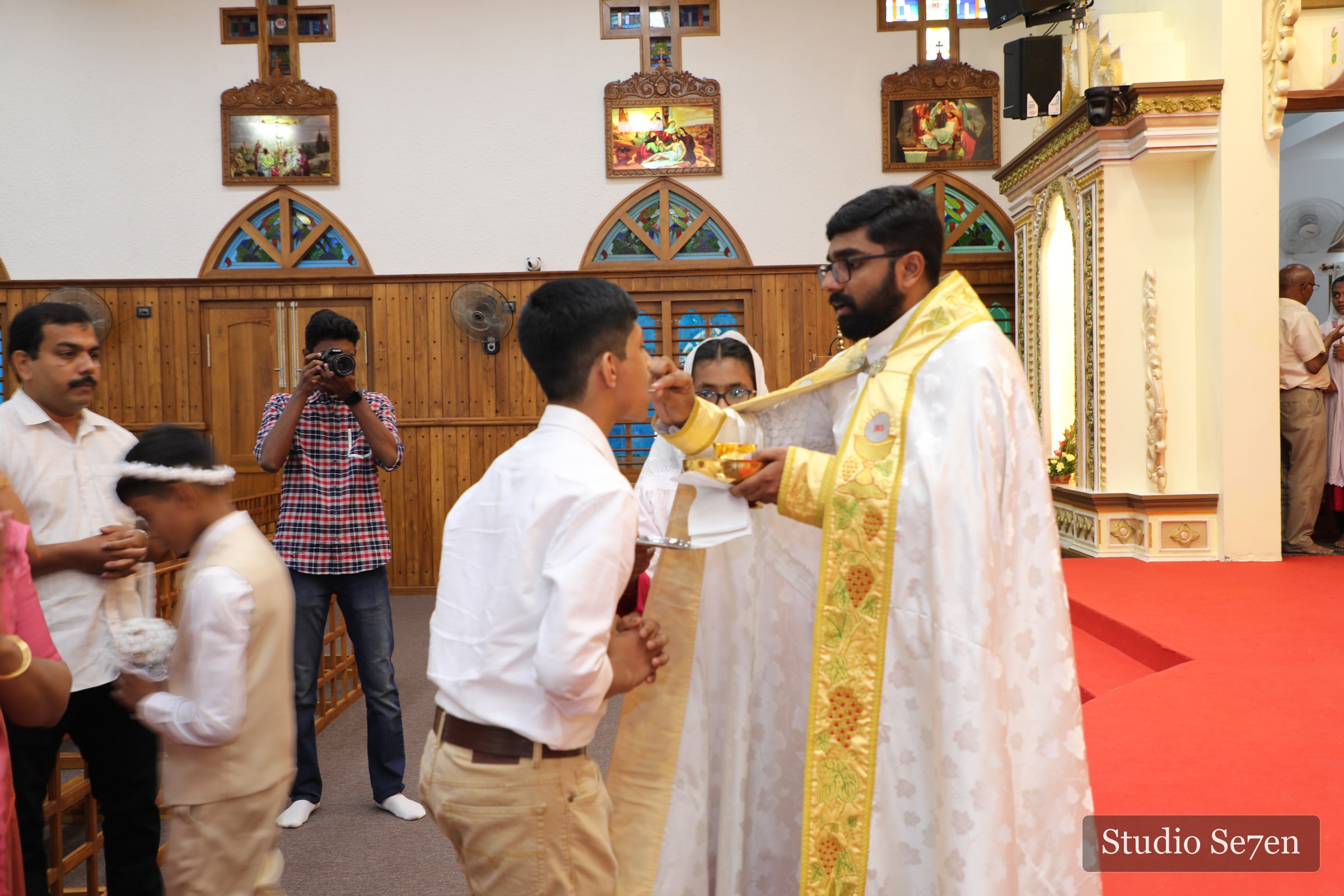 Ryan receiving Holy Communion from the priest inside the church