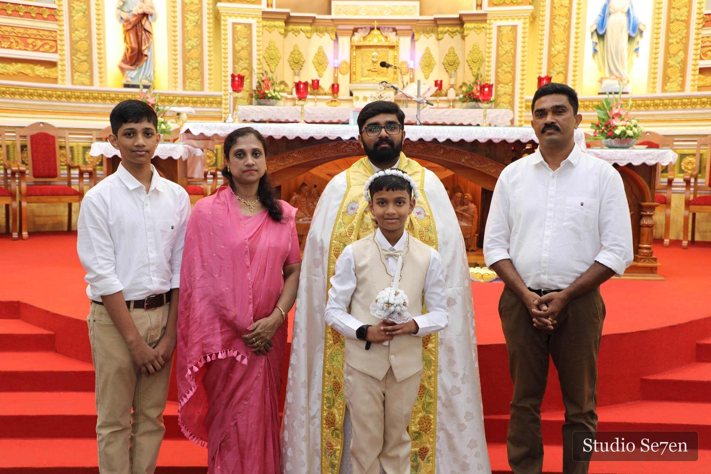 Ryan with his family and priest before the church altar