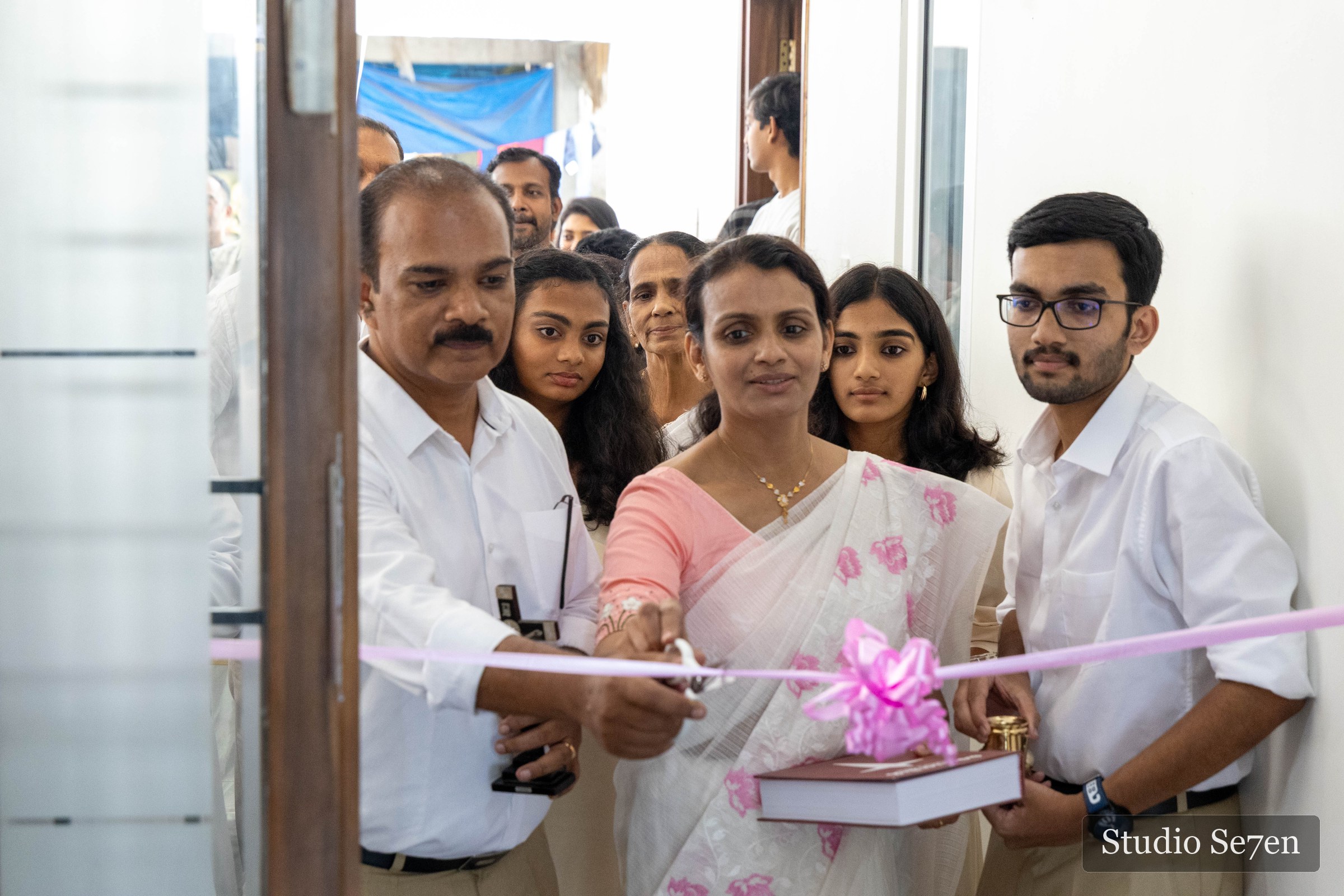 A family cutting the ribbon at their housewarming ceremony