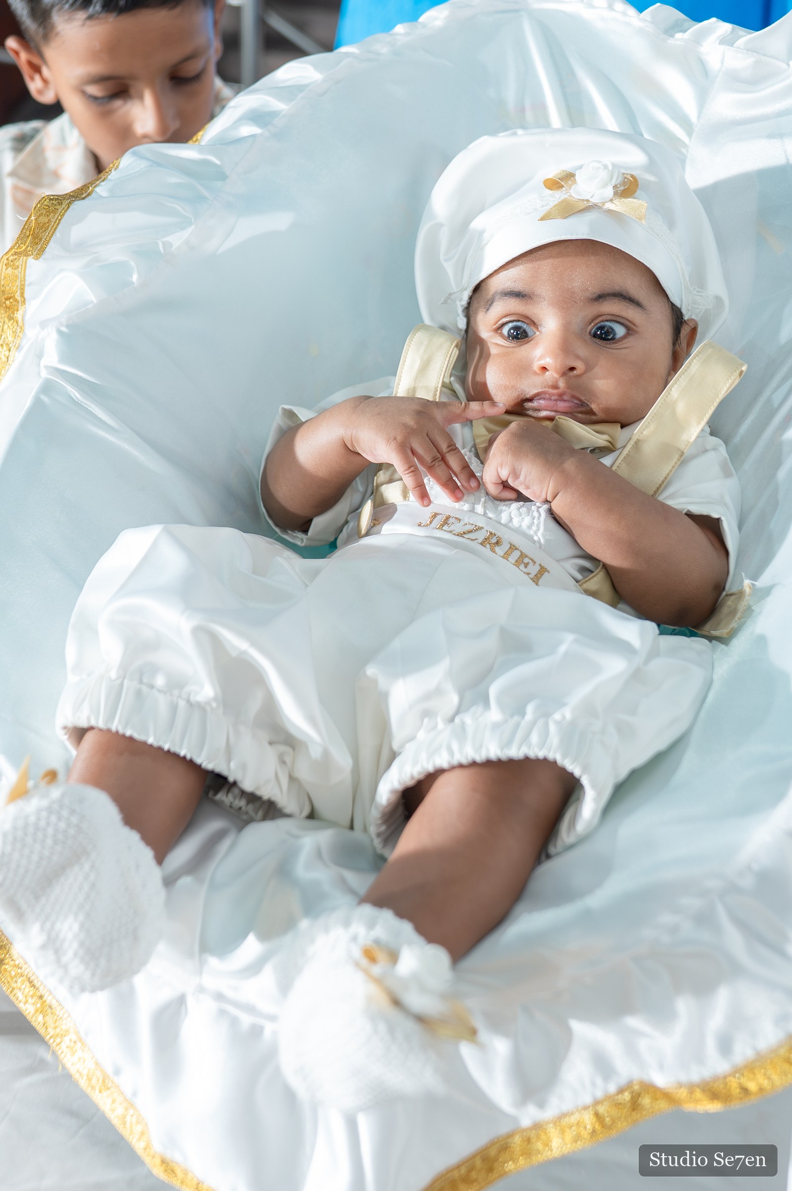 A quiet close-up of Jazriel resting in his white baptism outfit