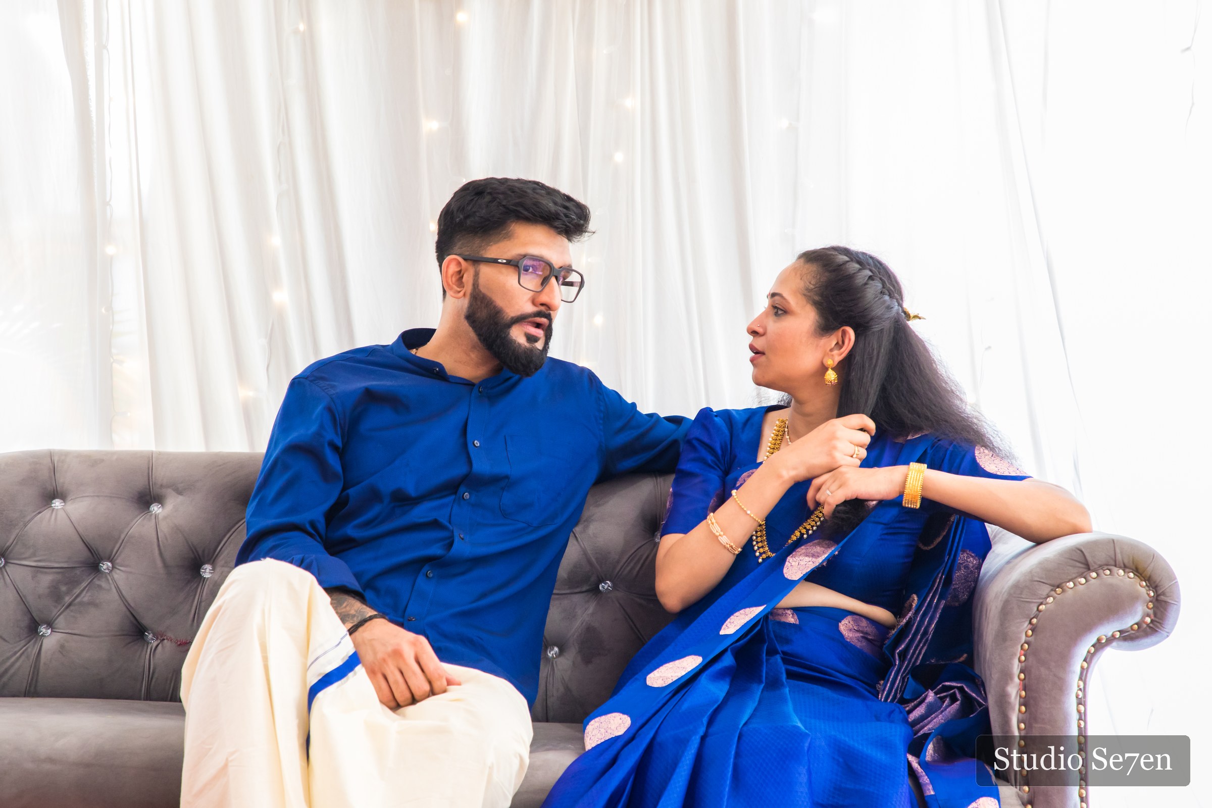 The engaged couple seated together for a relaxed portrait