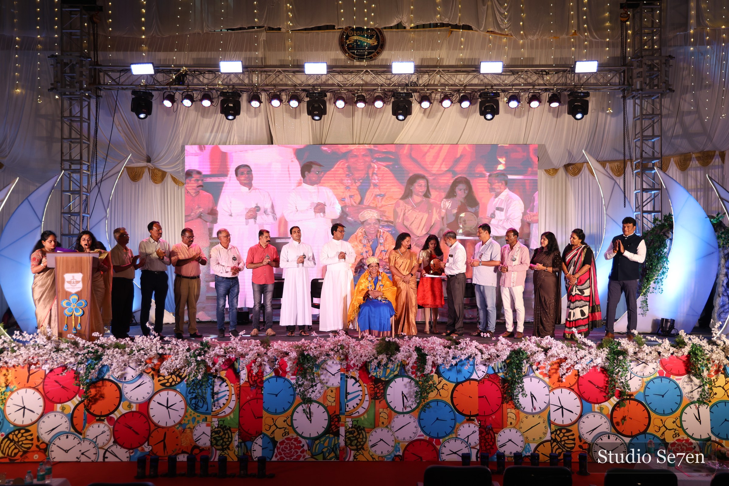 Students and teachers gathered across a brightly lit annual day stage