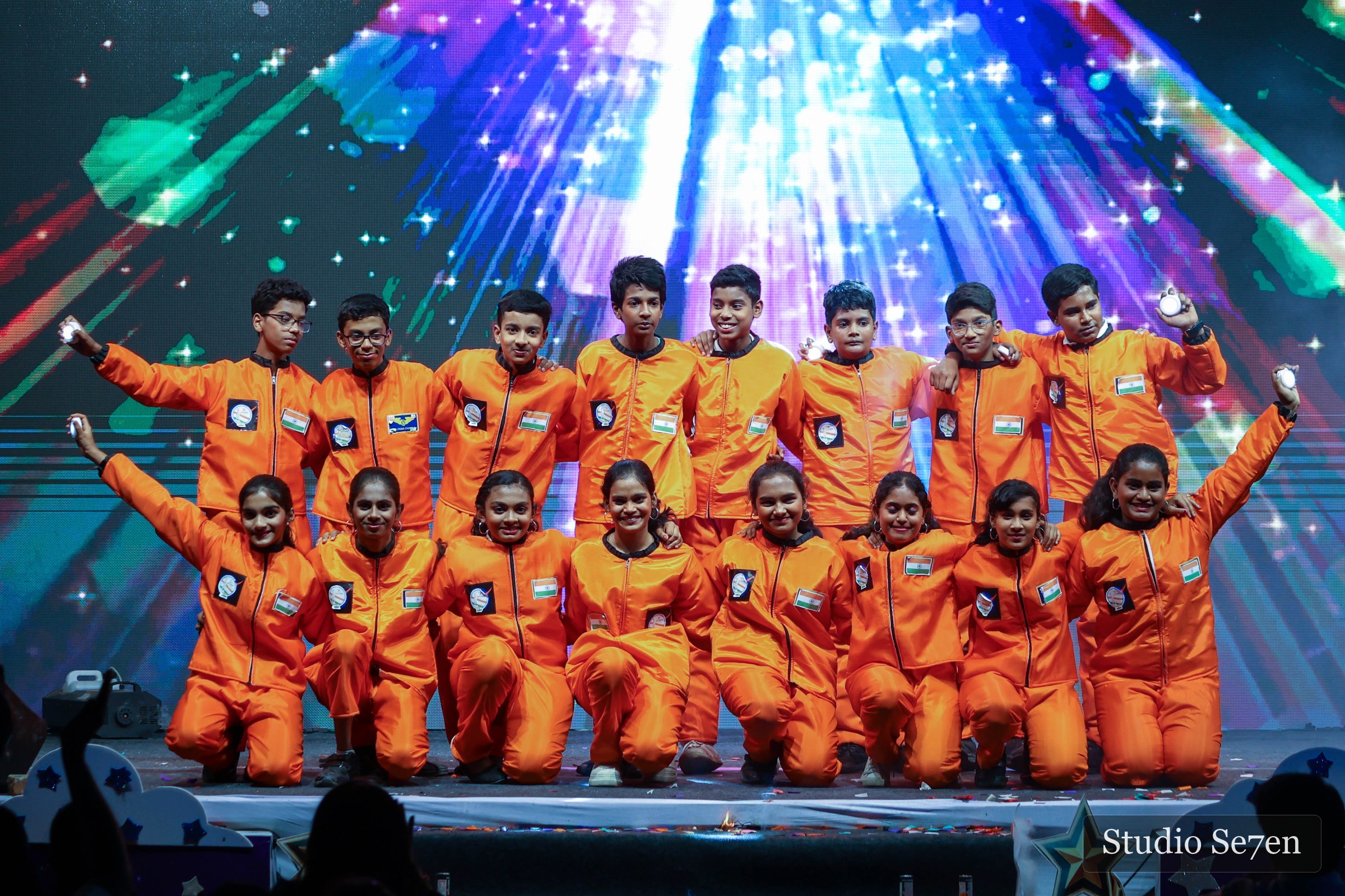 A large student ensemble completing a vibrant stage performance