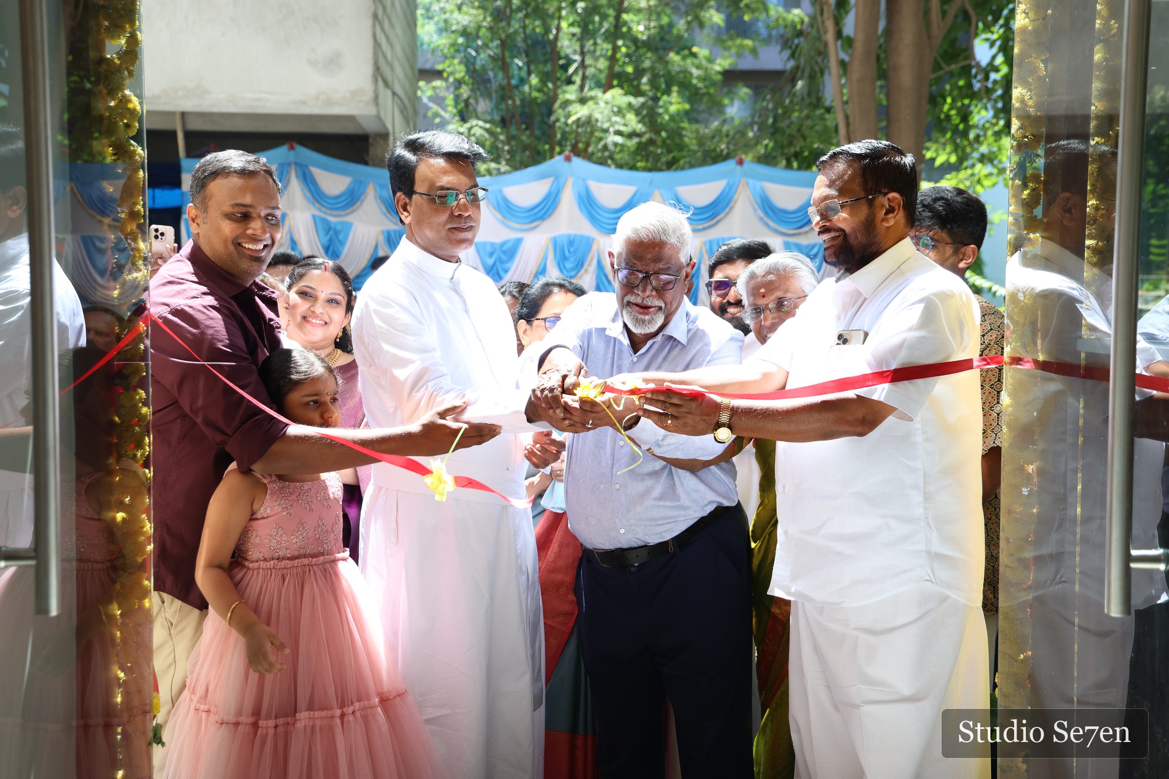 The Wilsons inauguration ribbon cutting with family and clergy gathered at the entrance